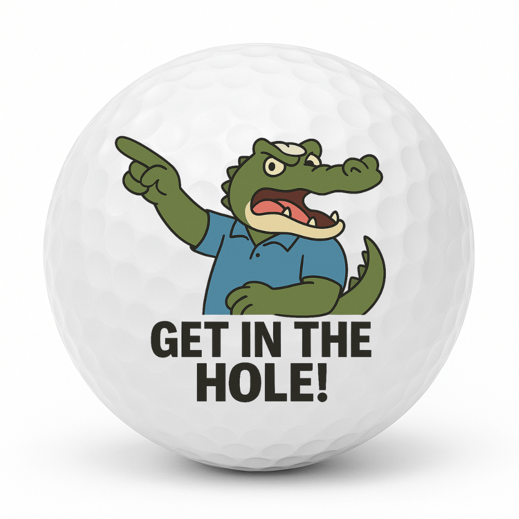 Cartoon crocodile golfer pointing and shouting with the text Get In The Hole on a white golf ball.