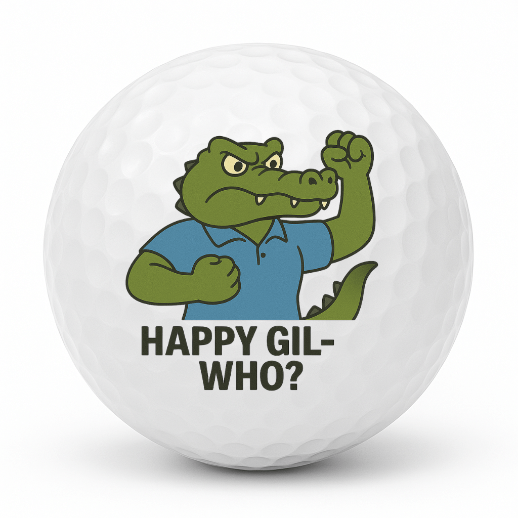 Cartoon crocodile golfer doing a fist pump with the text Happy Gil Who on a white golf ball.