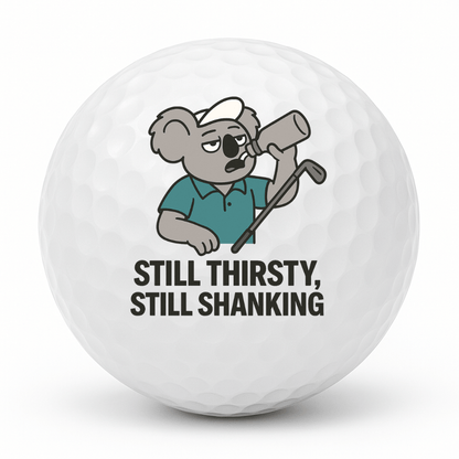Koala drinking from a bottle while holding a golf club with the text Still Thirsty Still Shanking printed on a novelty golf ball.